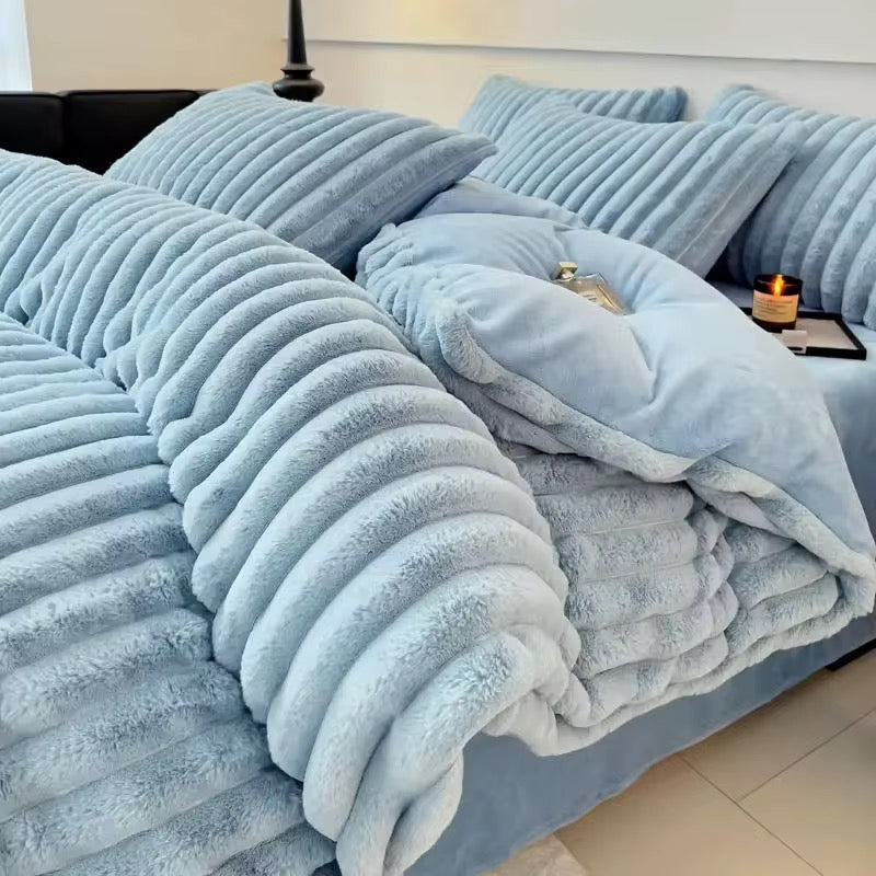 The Aspen is a luxurious and modern quilt cover set in a calming, powdery blue tone. The standout feature is its plush ribbed texture—deep, velvety channels that run across the comforter and pillows, creating an ultra-cozy, cloud-like effect. The fabric appears thick and inviting, perfect for cooler seasons, offering a cocoon of warmth and comfort