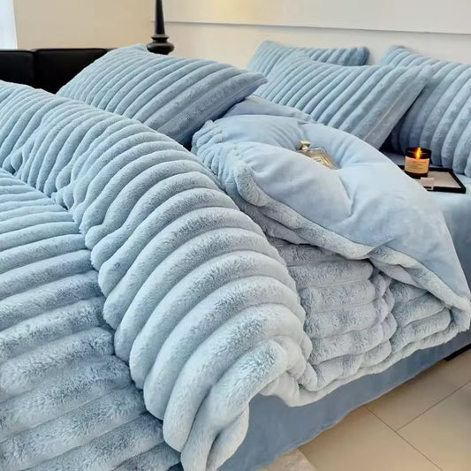 The Aspen is a luxurious and modern quilt cover set in a calming, powdery blue tone. The standout feature is its plush ribbed texture—deep, velvety channels that run across the comforter and pillows, creating an ultra-cozy, cloud-like effect. The fabric appears thick and inviting, perfect for cooler seasons, offering a cocoon of warmth and comfort